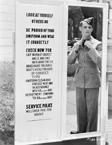 young airman checking uniform in mirror